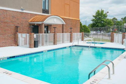 a large blue swimming pool in front of a building at Holiday Inn Express Hotel & Suites Hope Mills-Fayetteville Airport, an IHG Hotel in Hope Mills