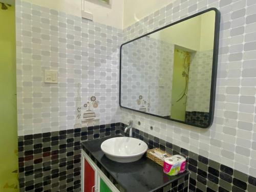 a bathroom with a sink and a mirror at Lagi Sunrise Hotel in La Gi