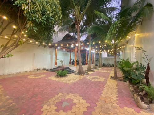 a courtyard with palm trees and lights in a building at Lagi Sunrise Hotel in La Gi