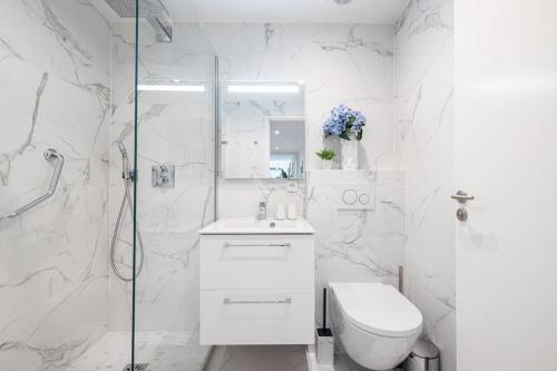 une salle de bain blanche avec toilettes et douche dans l'établissement Beautiful and Spacious 2 bed Apt with Pool, à Antibes