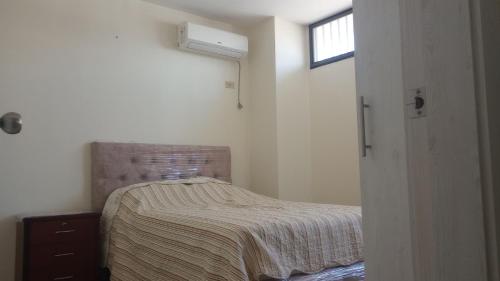 una piccola camera da letto con un letto e una finestra di Cozy Suite in cdla. Kennedy a Guayaquil