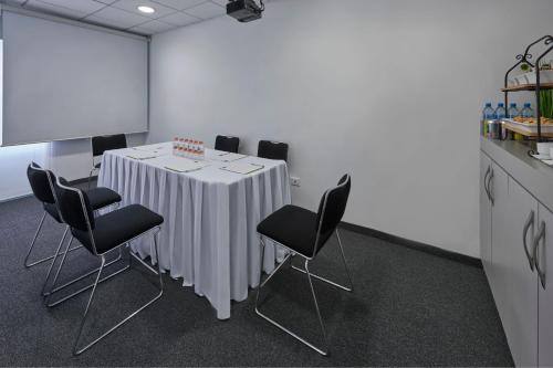 a conference room with a white table with black chairs at City Express Junior by Marriott Toluca Aeropuerto in Toluca