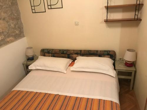ein Bett mit zwei Kissen auf einem Zimmer in der Unterkunft Anthea Rooms in Split