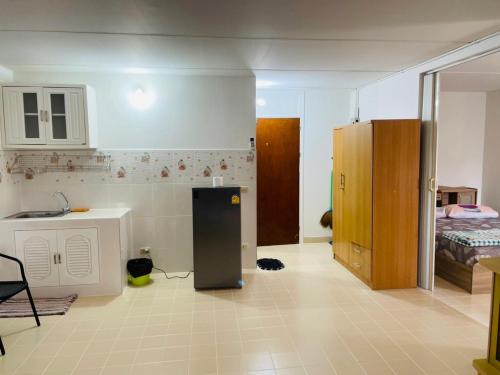 a kitchen with a refrigerator in the middle of a room at Dailyroom by Anna T1-T12 in Nonthaburi