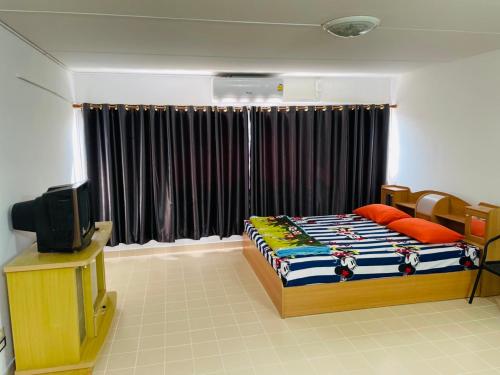 a bedroom with a bed and a television in it at Dailyroom by Anna T1-T12 in Nonthaburi