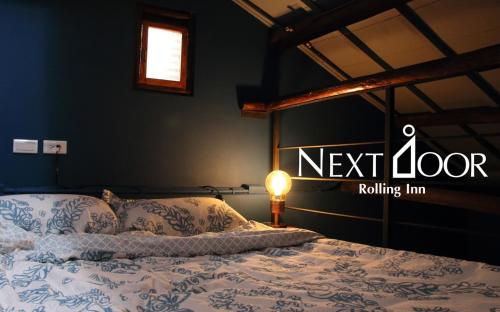 um quarto com uma cama com um letreiro de porta. em Rolling Inn B&B em Tainan