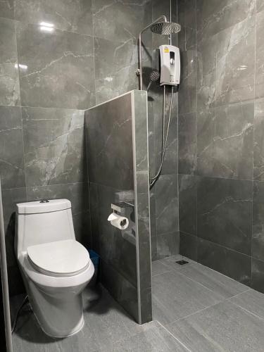 a bathroom with a shower with a toilet in it at Khampu Resident ก้ามปู เรสซิเด้นท์ in Maha Sarakham