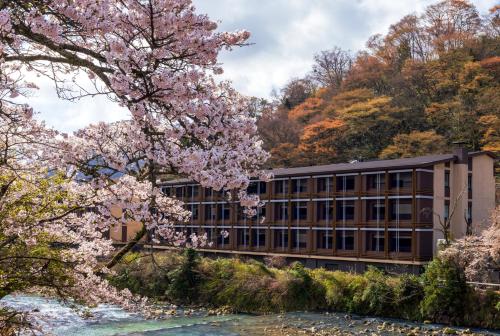 a building next to a river withakura trees at Hotel Indigo Hakone Gora, an IHG Hotel in Hakone
