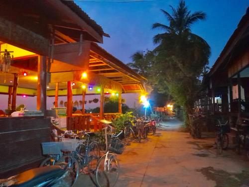 - un groupe de vélos garés devant un restaurant la nuit dans l'établissement Sun down dondet bungalows, à Don Det