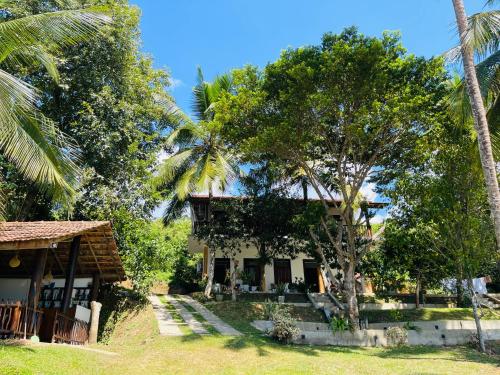 uma casa com palmeiras em frente em Hari Villa Mirissa em Mirissa
