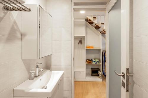 een witte badkamer met een wastafel en een spiegel bij The Blue Loft Seminyak free scooter in Seminyak