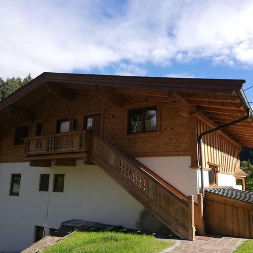 Una casa con una escalera al costado. en Gemütliche Wohnung mit Blick auf den Zahmen Kaiser, en Niederndorferberg