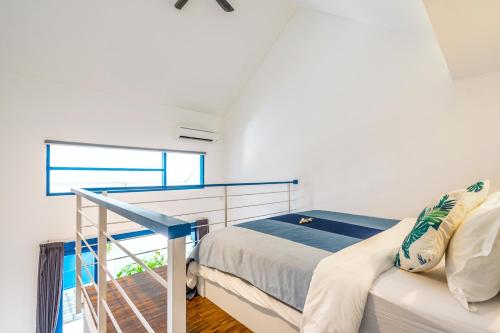 1 dormitorio con 1 cama y balcón en The Blue Loft Seminyak free scooter en Seminyak