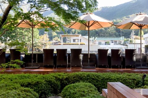 a group of chairs and umbrellas on a patio at Hotel Indigo Hakone Gora by IHG in Hakone