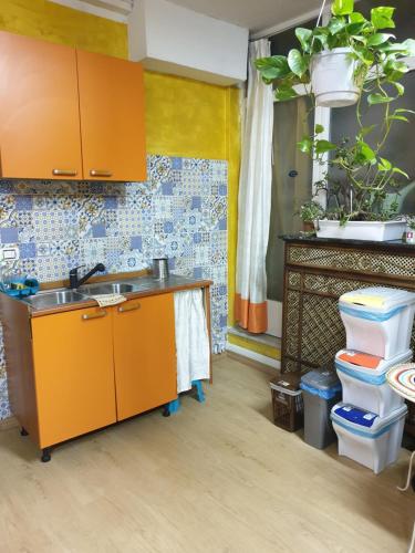 eine Küche mit orangefarbenen Schränken und einem Waschbecken in der Unterkunft Laya Valentina in Turin