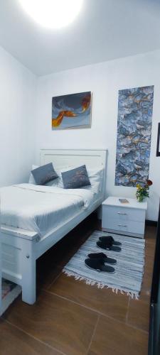 a bedroom with a white bed and a rug at Dukes Suites in Nairobi