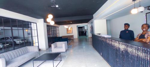 two people standing at a bar in a room at Dukes Suites in Nairobi