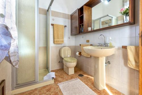 uma casa de banho com um WC, um lavatório e um chuveiro em Nausica's Apartment em Trinità d'Agultu e Vignola