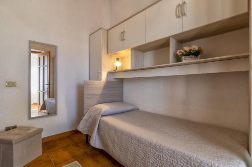 een slaapkamer met een bed en een spiegel bij Nausica's Apartment in Trinità dʼAgultu