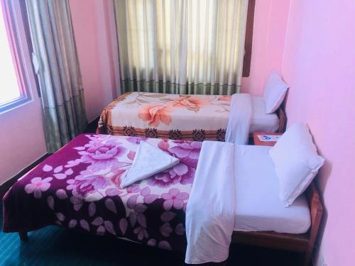 a small room with two beds and a chair at Hotel Green Orchid in Kathmandu