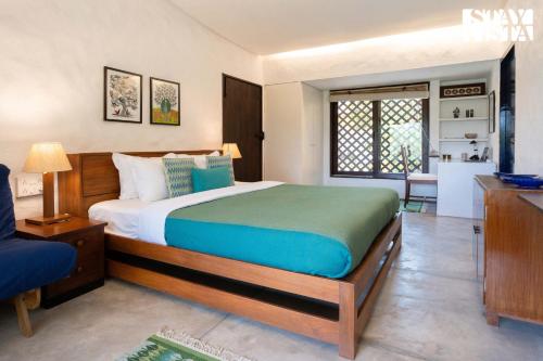 a bedroom with a large bed in a room at The Courtyard by StayVista - Private Pool with Rustic Charm, Vibrant Courtyard, Spacious Verandah & Garden in Alibag