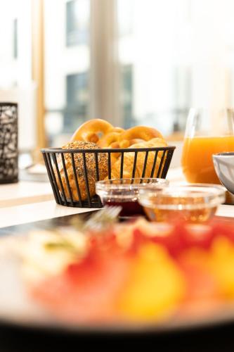 a table with a basket of donuts and orange juice at DEKRA Congresshotel Wart in Altensteig