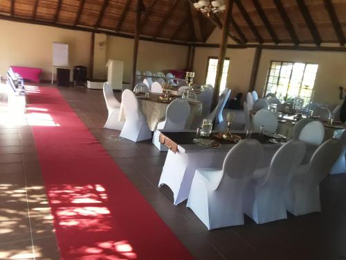 a room with white tables and white chairs and a red carpet at Loding Lodge in Loding