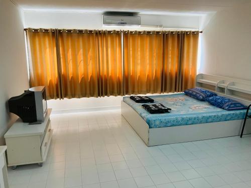 a bedroom with a bed and a television in it at Muangthong T4,T5near Impact,Challenger in Nonthaburi