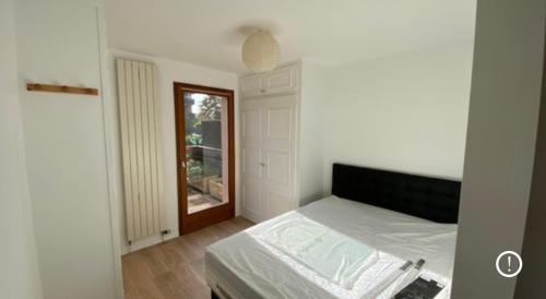 une chambre blanche avec un lit et une fenêtre dans l'établissement Jolie T2 - très grande terrasse, à Thonon-les-Bains