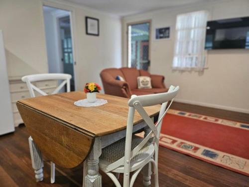 - Sala de estar con mesa y sillas en Amamoor Lodge, en Amamoor