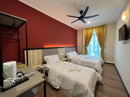 Alia Express Dey Hotel Kota Bharu في Kota Bharu: غرفة فندقية بسريرين ومروحة سقف