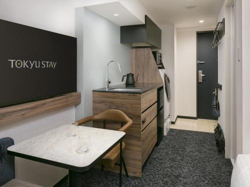 a small kitchen with a table and a sink at Tokyu Stay Nishi Shinjuku in Tokyo