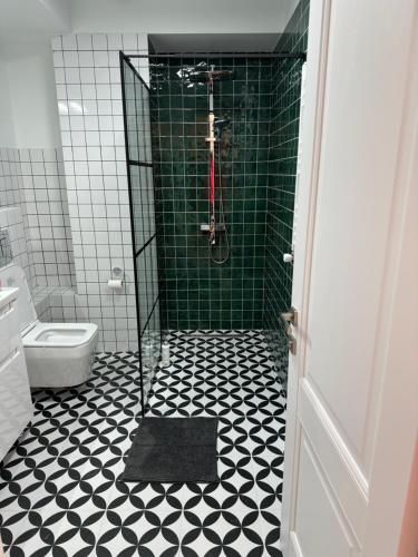 baño con ducha y suelo blanco y negro en Cozy one bedroom apartment in New Gudauri, en Gudauri