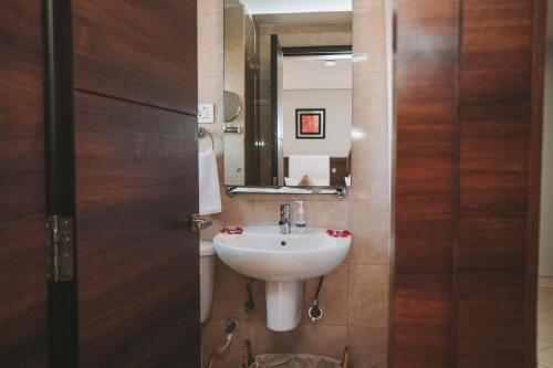 a bathroom with a sink and a mirror at Peerless Hotel Durgapur in Durgāpur