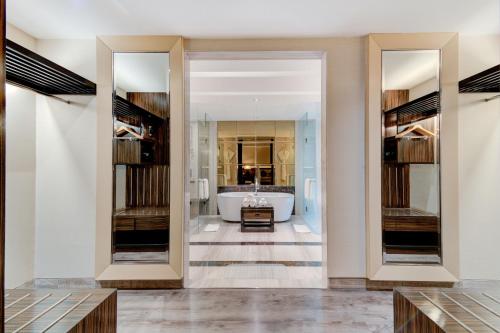 a bathroom with a tub and a large mirror at Hyatt Ahmedabad in Ahmedabad
