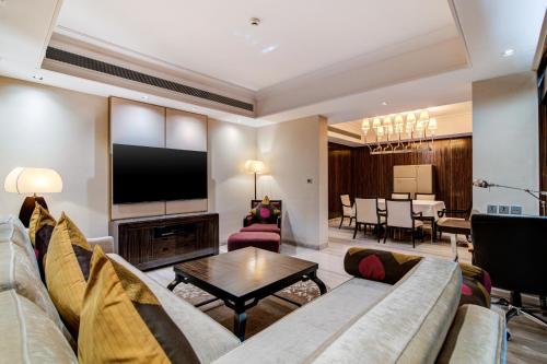 a living room with a couch and a tv at Hyatt Ahmedabad in Ahmedabad