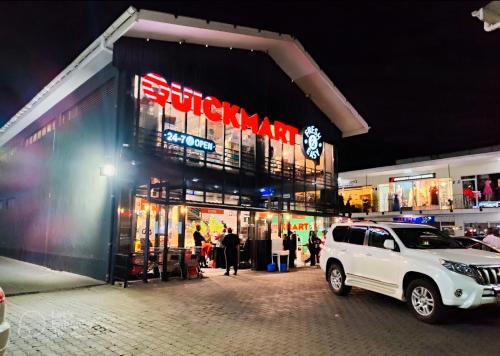 a white suv parked in front of a store at Dukes Suites in Nairobi