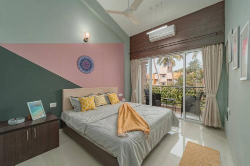 アンジュナにあるEarthlings : Anjuna beach- 2BHK with swimming poolのベッドルーム1室(ベッド1台、大きな窓付)