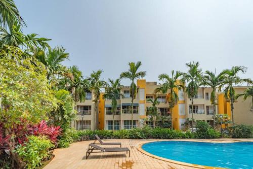 a resort with a swimming pool and palm trees at Earthlings : Anjuna beach- 2BHK with swimming pool in Anjuna
