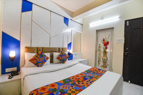 a bedroom with a large bed with colorful pillows at FabHotel Green Leaf I in Kolkata