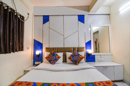 a bedroom with a bed with blue and white walls at FabHotel Green Leaf I in Kolkata