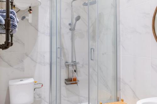 une douche avec une porte vitrée dans une salle de bain dans l'établissement T2 Chic, Vue Vieux-Port et Notre Dame, Atypique, Calme, Clim, 48M2, Accès autonome avec code, à Marseille
