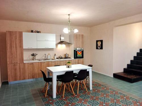 una cocina con una mesa blanca y algunas sillas en Vigna di pettineo - guest house en Vittoria