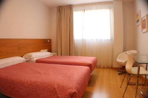 Habitación de hotel con 2 camas y ventana en Hotel Picos De Europa en Santander