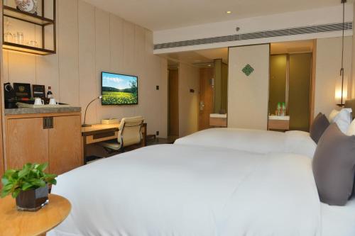 a hotel room with a bed and a desk at The Garden Hotel Guangzhou - Discover 26 cultural treasures with hotel Golden Tour Guide in Guangzhou