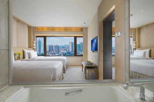 a hotel room with two beds and a bath tub at The Garden Hotel Guangzhou - Discover 26 cultural treasures with hotel Golden Tour Guide in Guangzhou