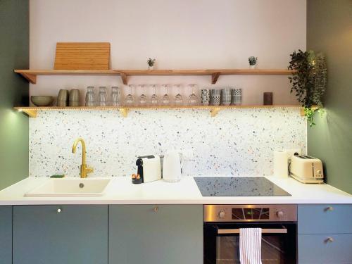 une cuisine avec un évier et un plan de travail dans l'établissement L'Olivier F2 de standing au cœur du vieux Pontoise, à Pontoise