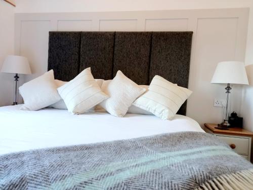 a bedroom with a large white bed with white pillows at Irfon Cottage in Builth Wells