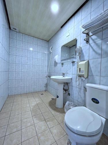 a bathroom with a toilet and a sink at Fulong Hotel in Zhongli