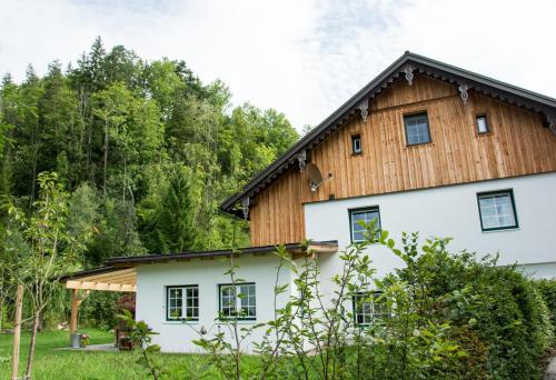 ein großes weißes Haus mit Holzdach in der Unterkunft Haus Schatzl in Bad Aussee